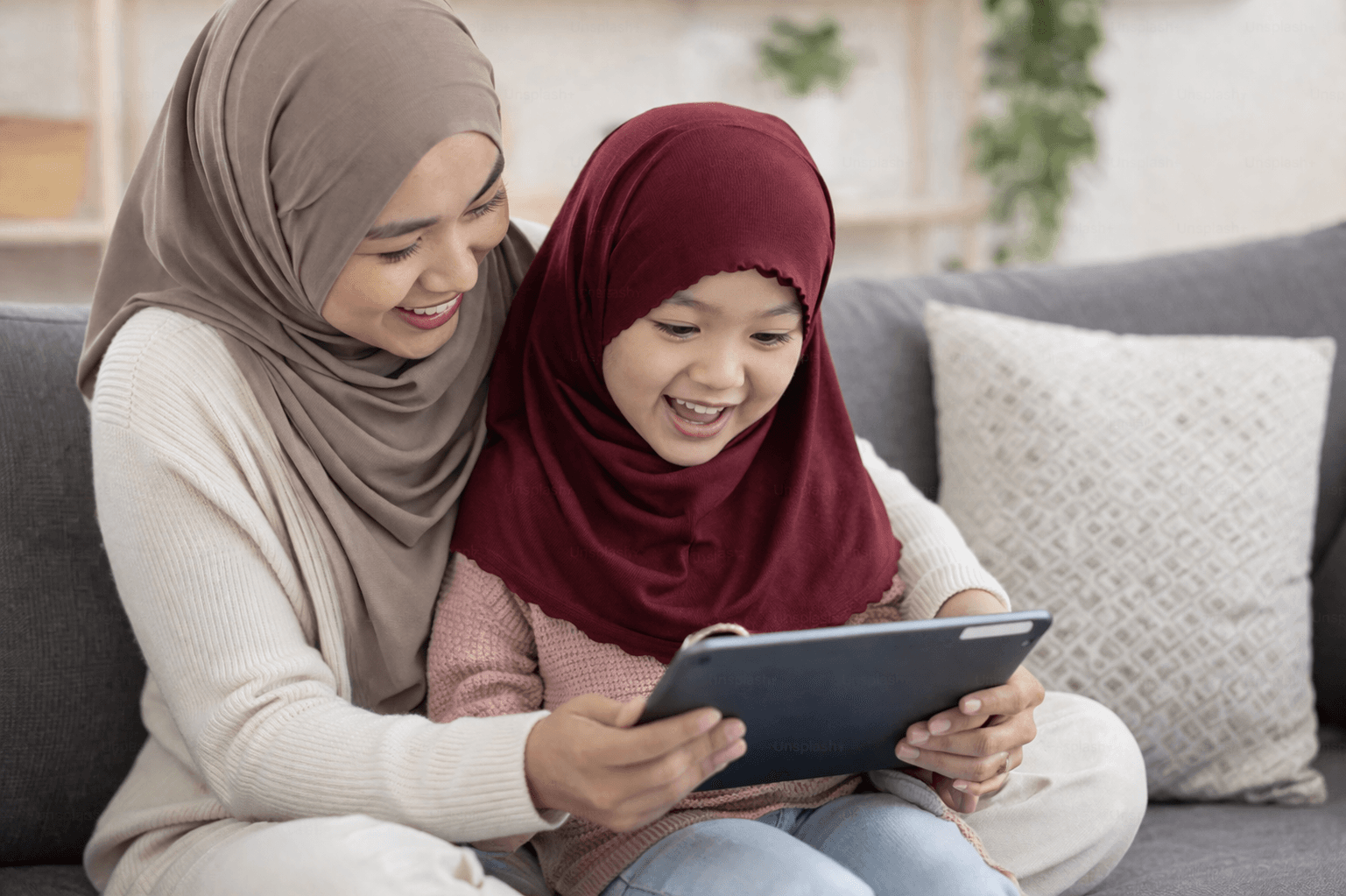 Mother and daughter learning Quran together on a tablet